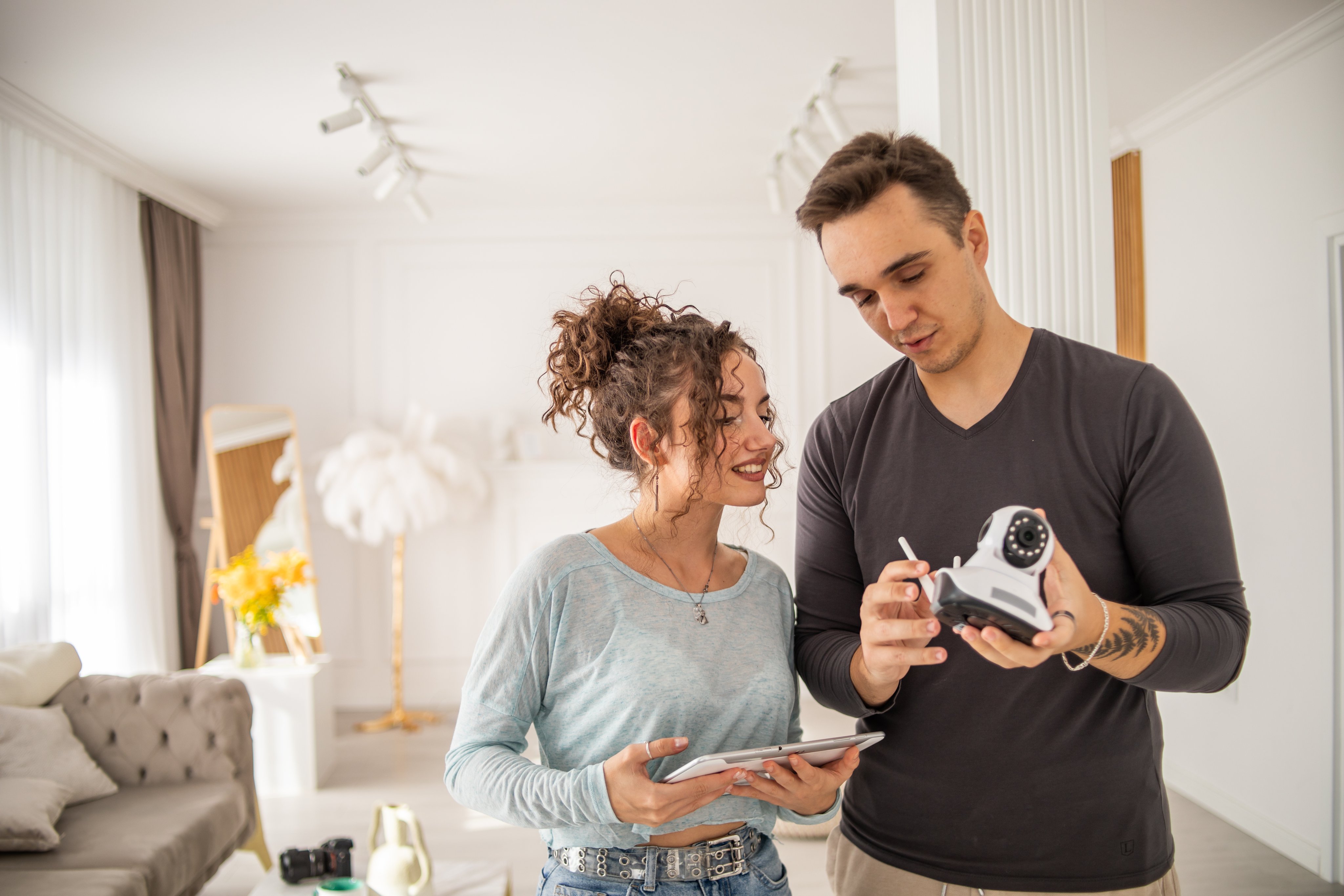 A young couple installs a security camera in their new home