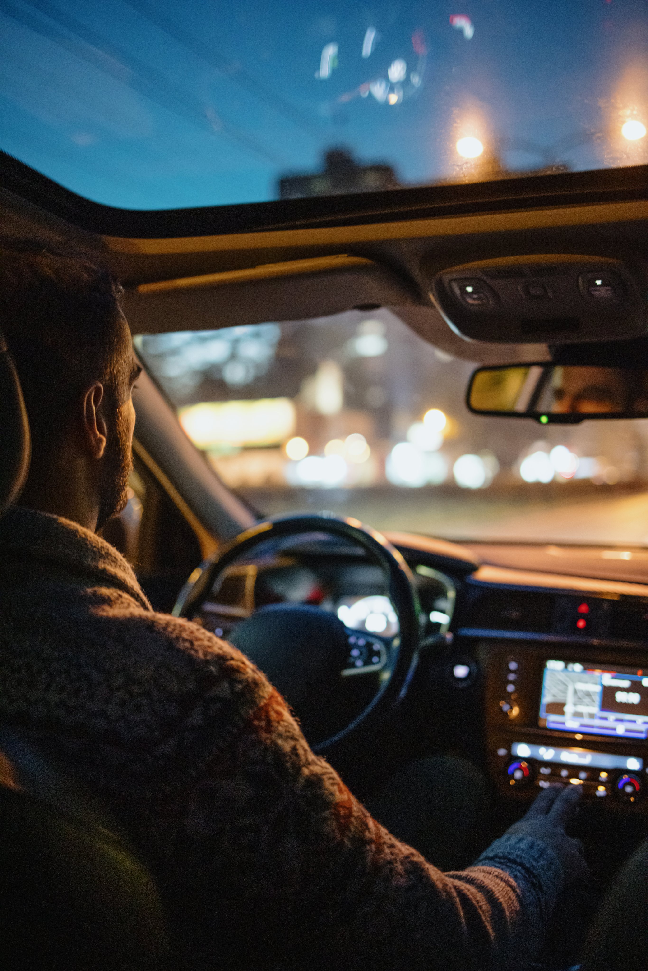 Man driving car in the city streets at night