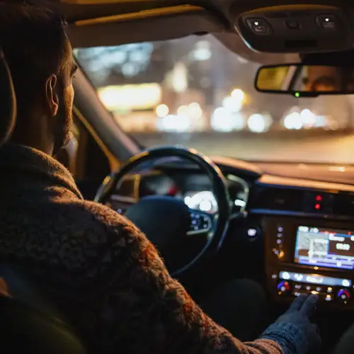 Man driving car in the city streets at night