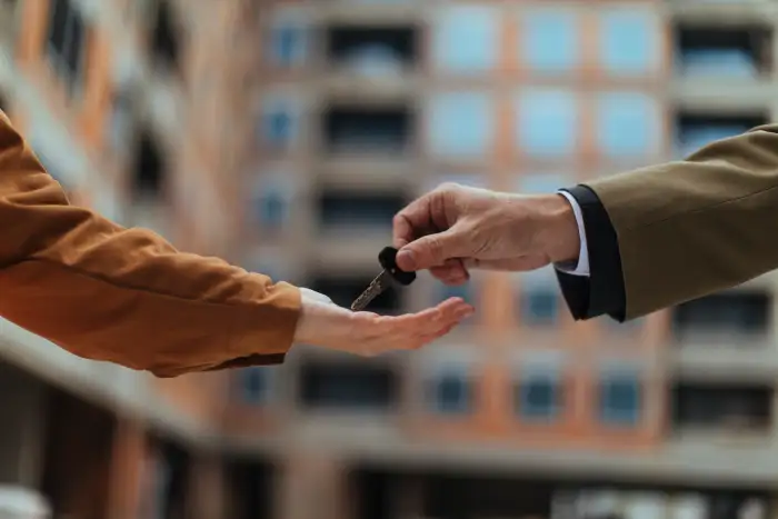 Photo of man handing over key to apartment