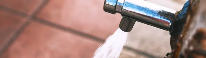 Faucet is dripping water onto a sidewalk
