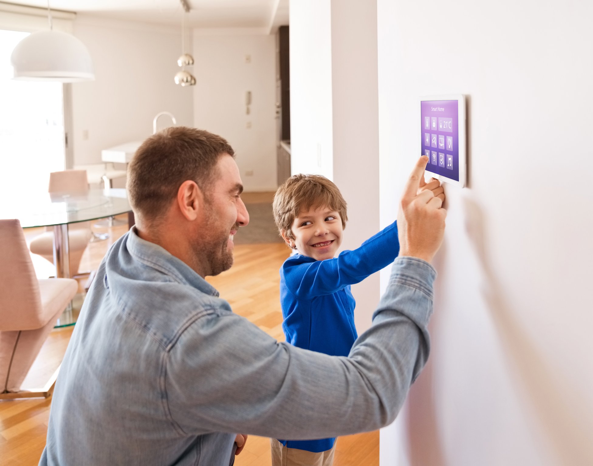 Father with son controlling smart home devices with a digital tablet