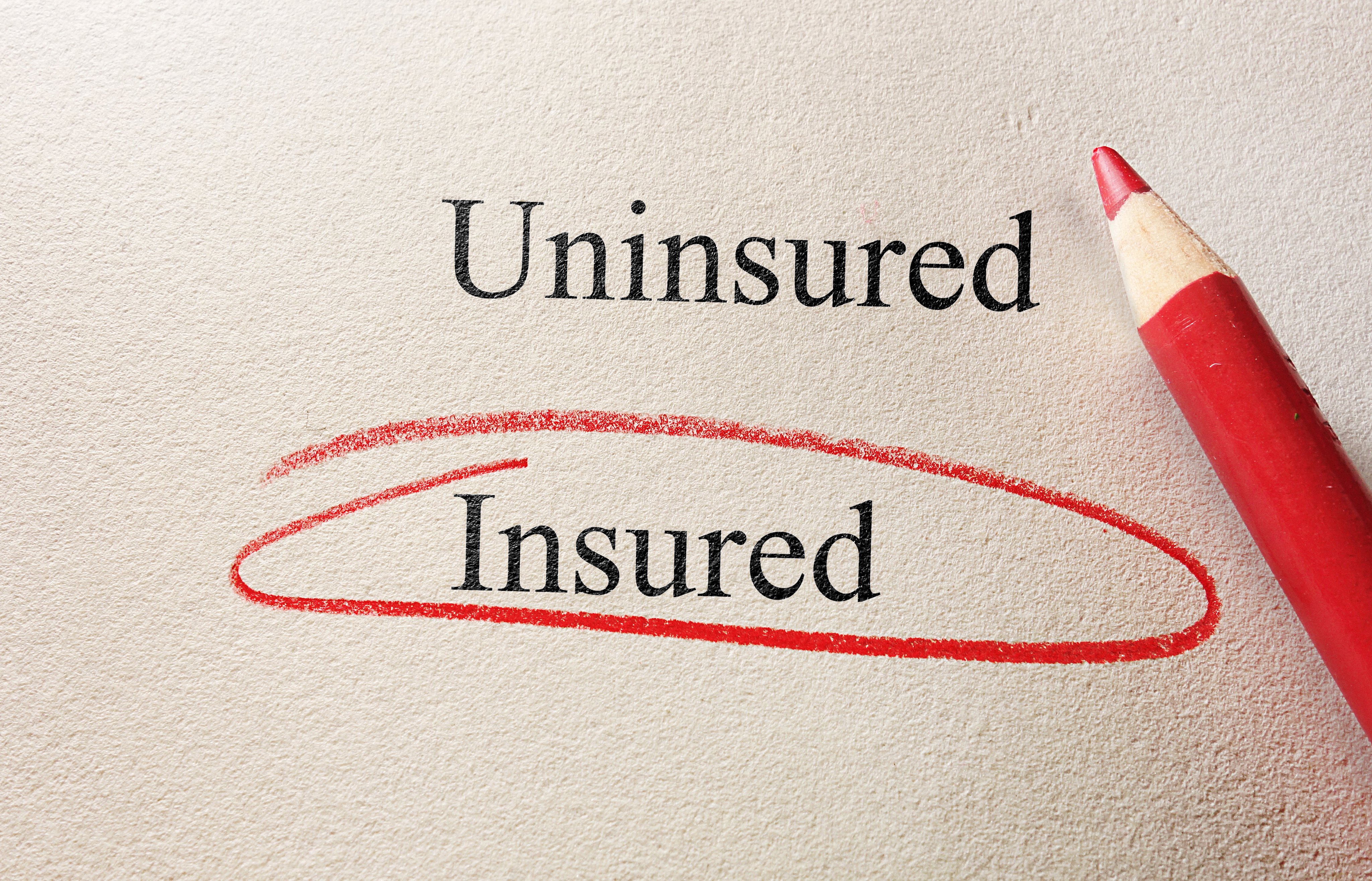 Piece of paper and red pencil with the word insured circled in red