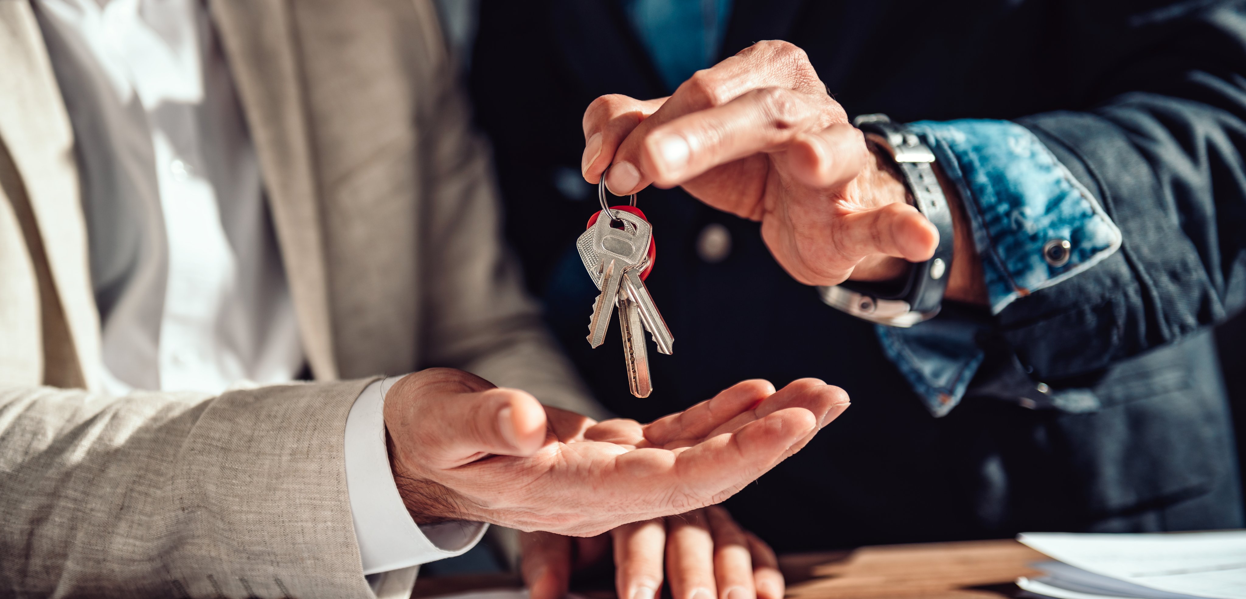 Real estate agent passing apartment keys to a client in the office