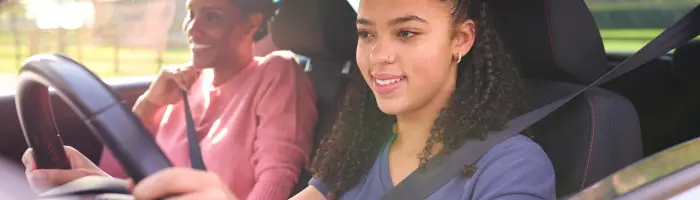 Teenage girl in car having driving lesson