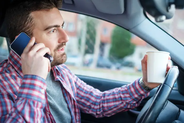 Man talking on the smartphone and driving a car