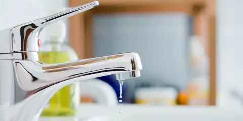 Sink faucet with water dripping from the spout