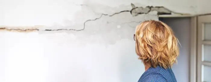 Woman looking at a wall damaged after the earthquake
