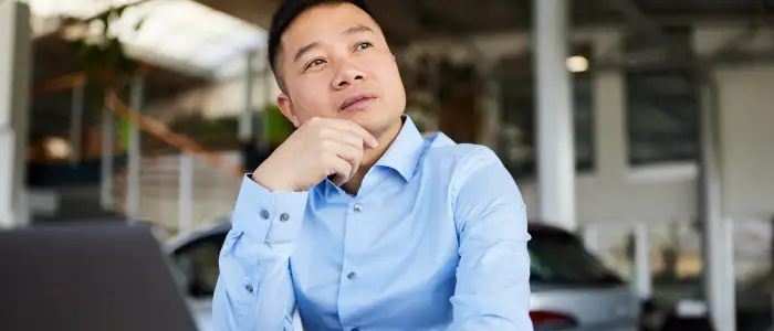 Asian male customer considering a new car purchase