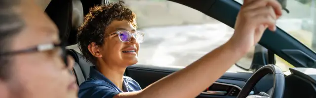 Fillipino American teaching her multiracial son how to drive