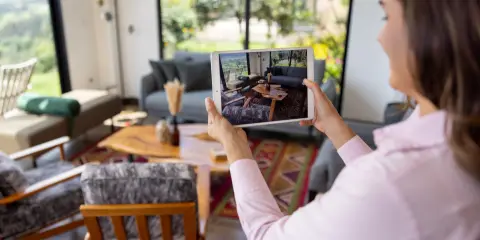 Woman photographing modern living room furniture with a tablet