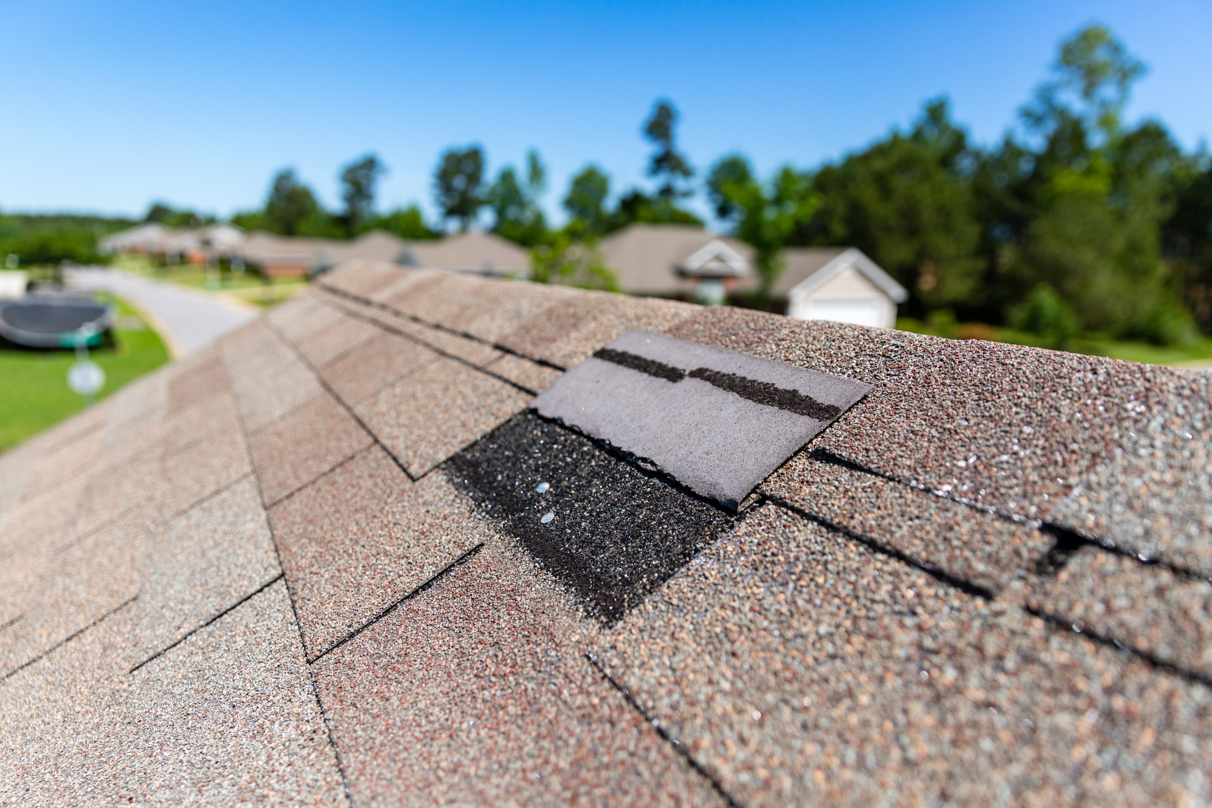 Missing shingles on roof due to storm damage.