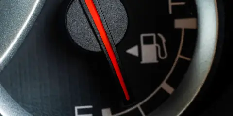 Close-up of a car&rsquo;s fuel gauge showing the fuel pump icon indicating the gas cap is on the left side