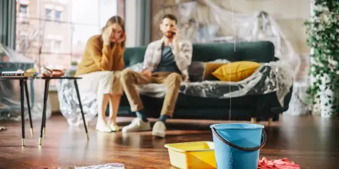 Young couple saving coins into a piggy bank