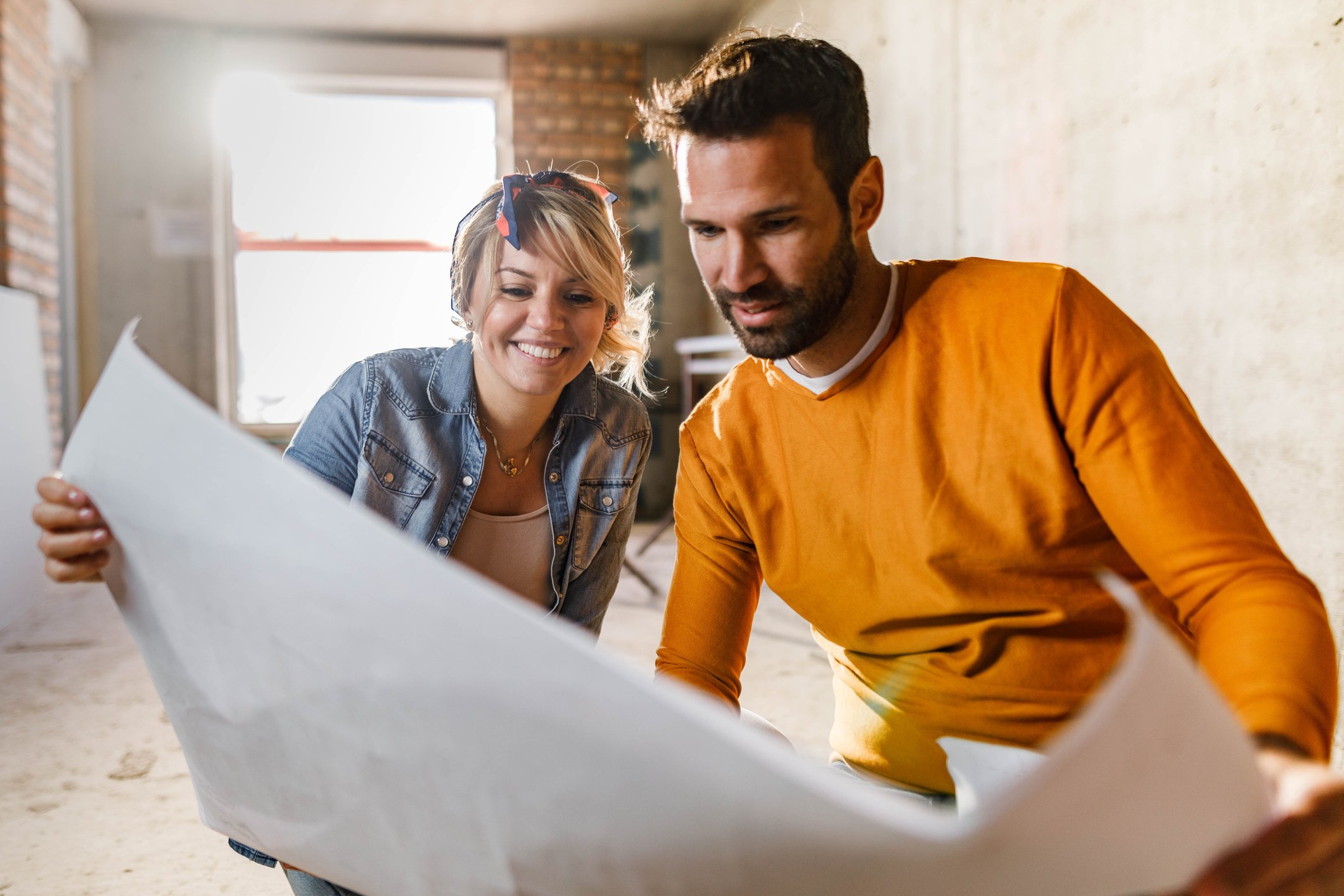 Young couple examining blueprints during home renovation process