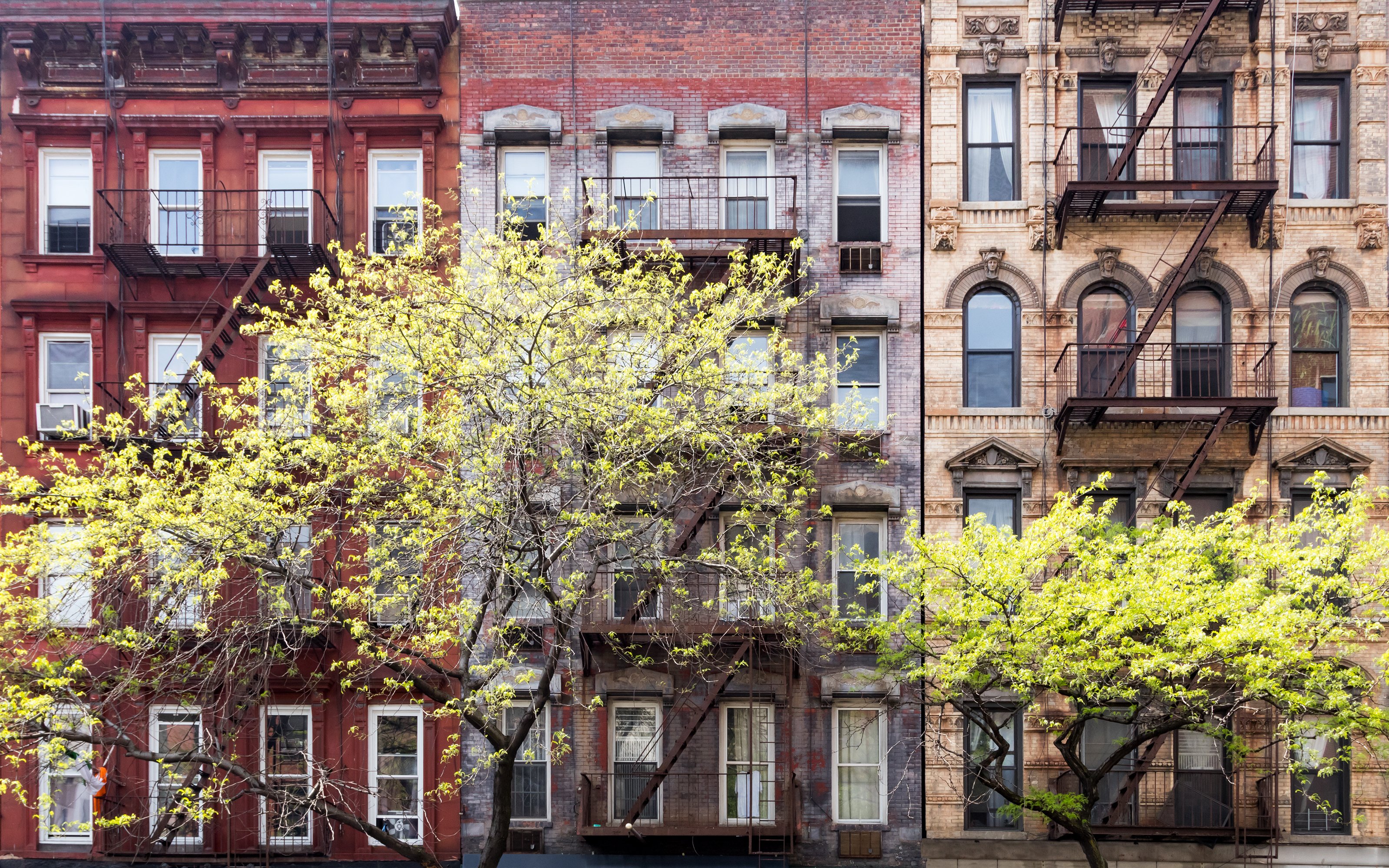 Historic old buildings and trees along 3rd Avenue in the East Village of Manhattan, New York City NYC