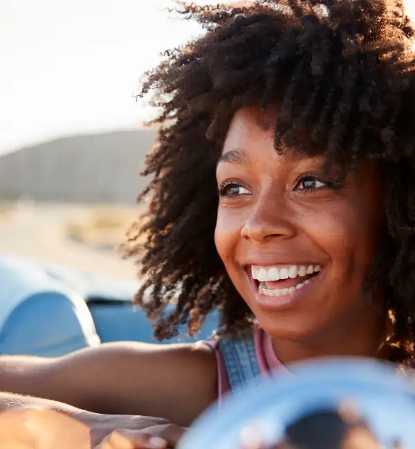 Portrait of woman enjoying road trip in open top classic car