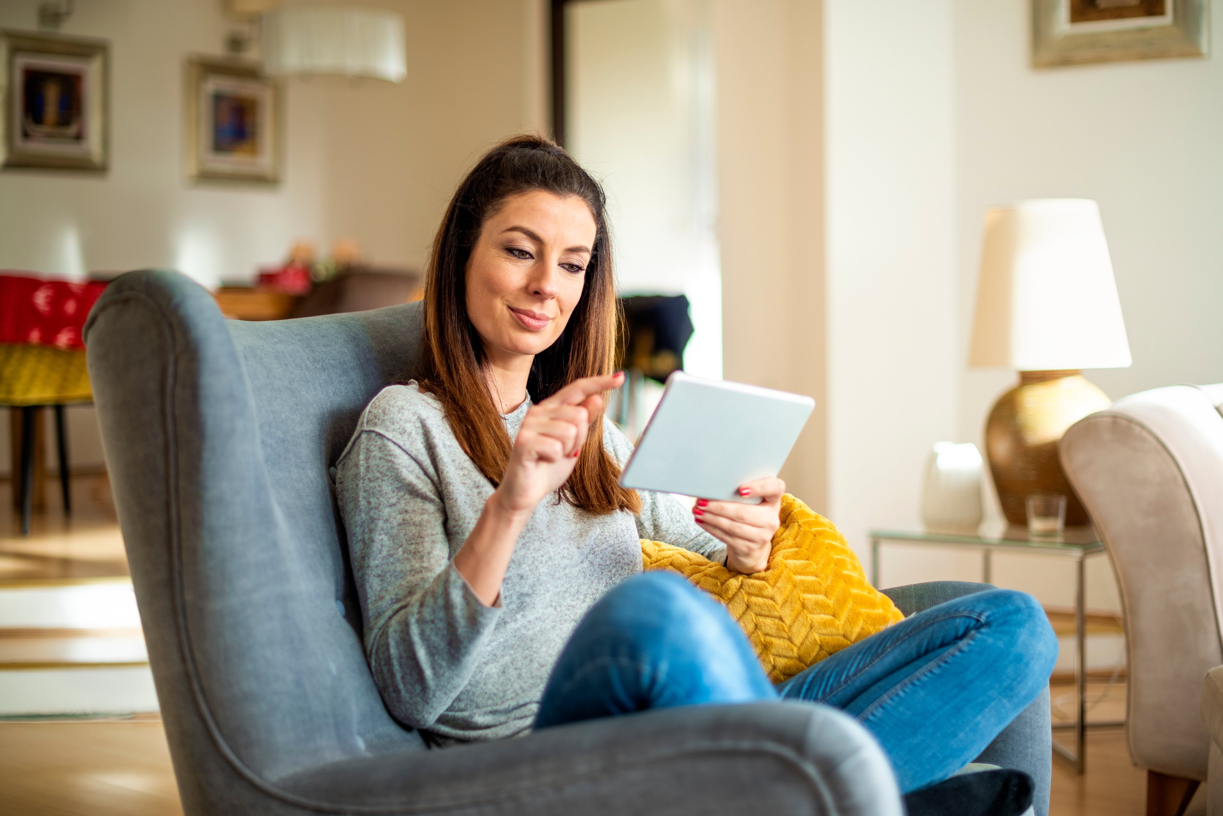 Woman with digital tablet relaxing at home