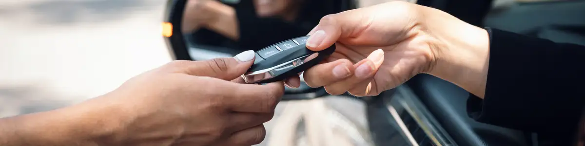 Shot of car rental agency employee giving car keys to woman