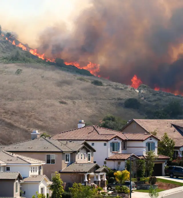 Hillside wildfire endangering homes