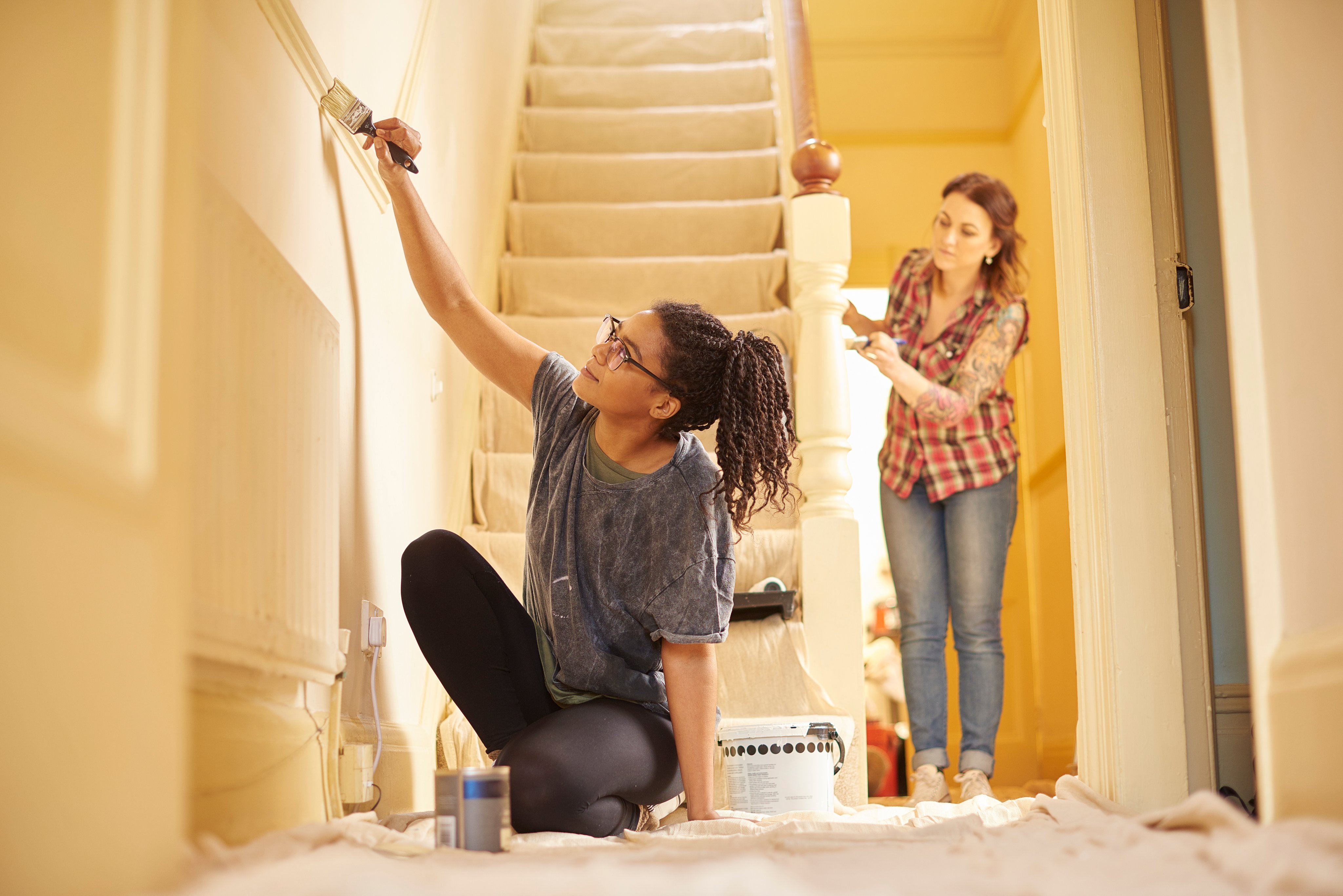 Ladies painting and repairing the entrance of their home