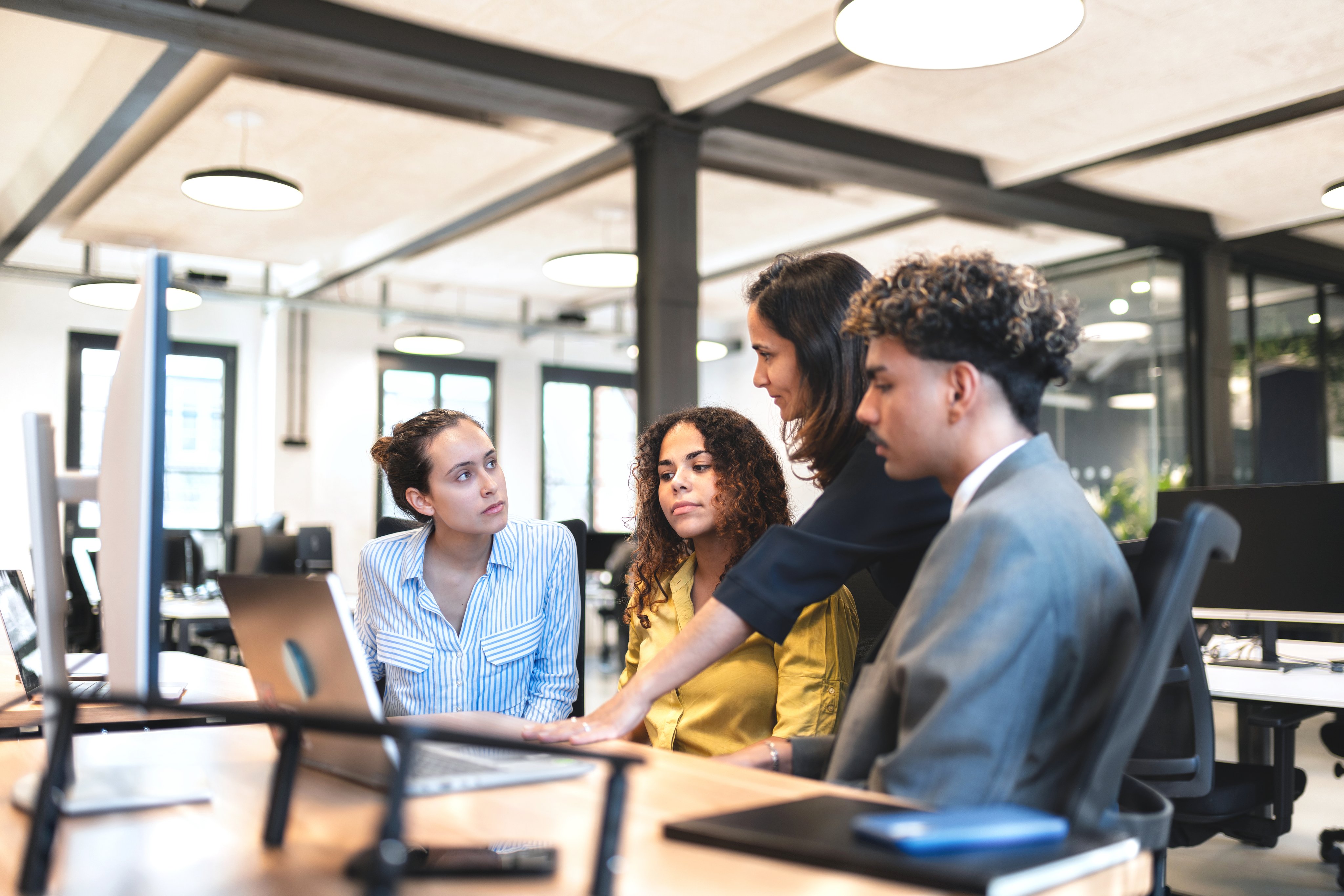 Develop team talking while gathered around a computer