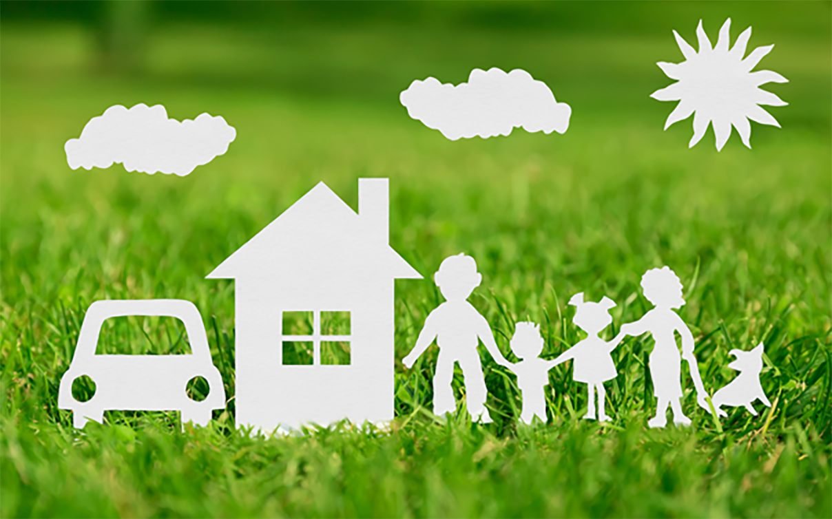 Paper cut out family holding hands next to paper car and house