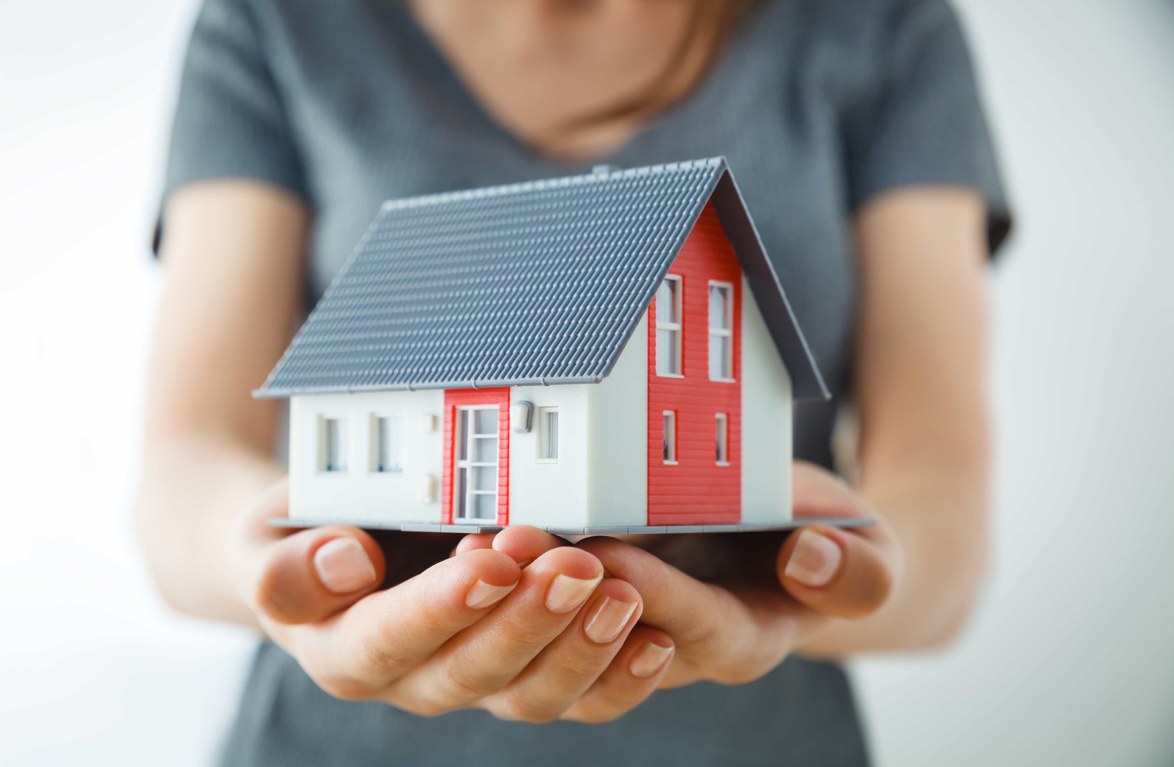 Woman holding a model house in her hands