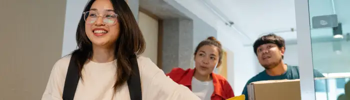 Asian parent helping two sister to carry belongings and exciting when entering into new dormitory.