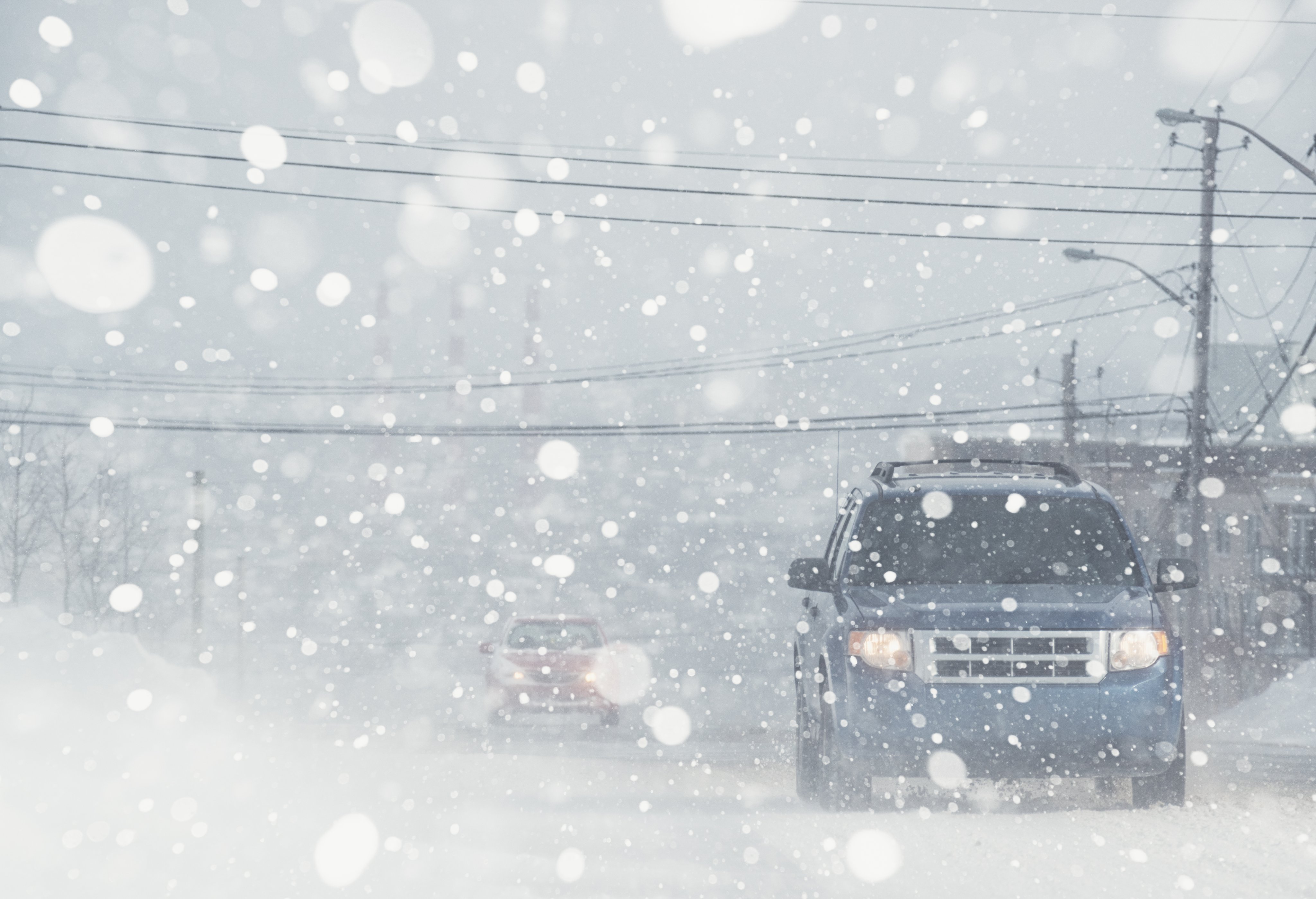 Motorists navigate a city street in white out conditions