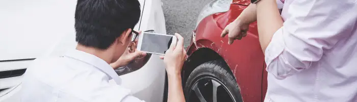 Two drivers man arguing after a car traffic accident collision and making phone call to Insurance Agent and take a photo