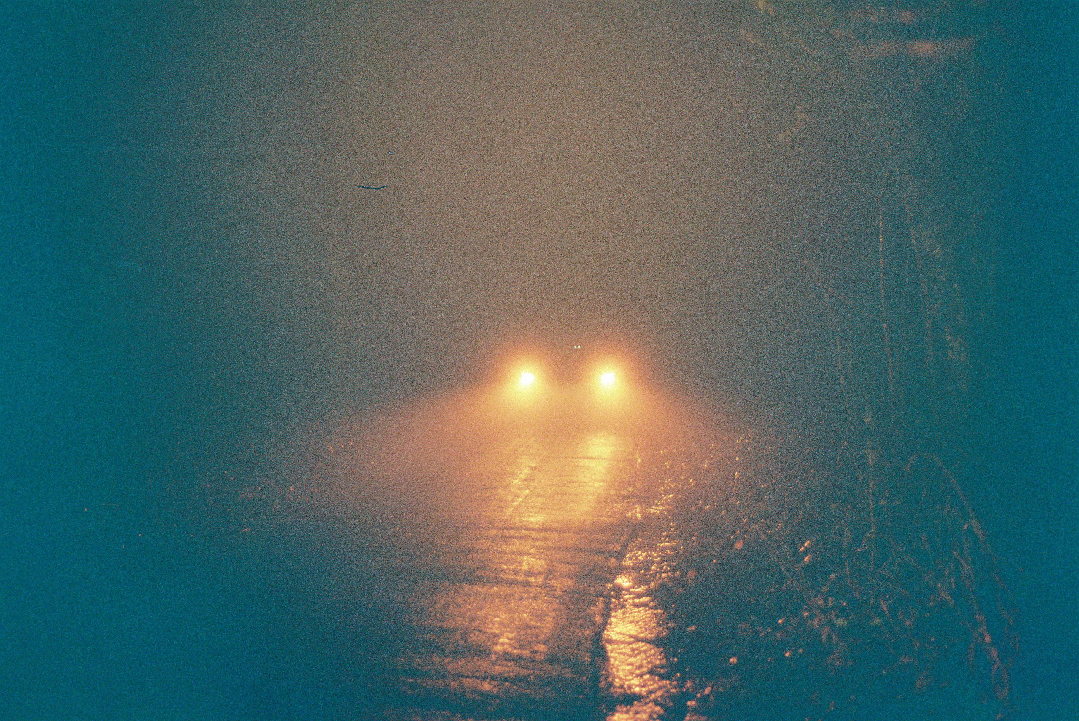 Car driving on spooky night on country lane