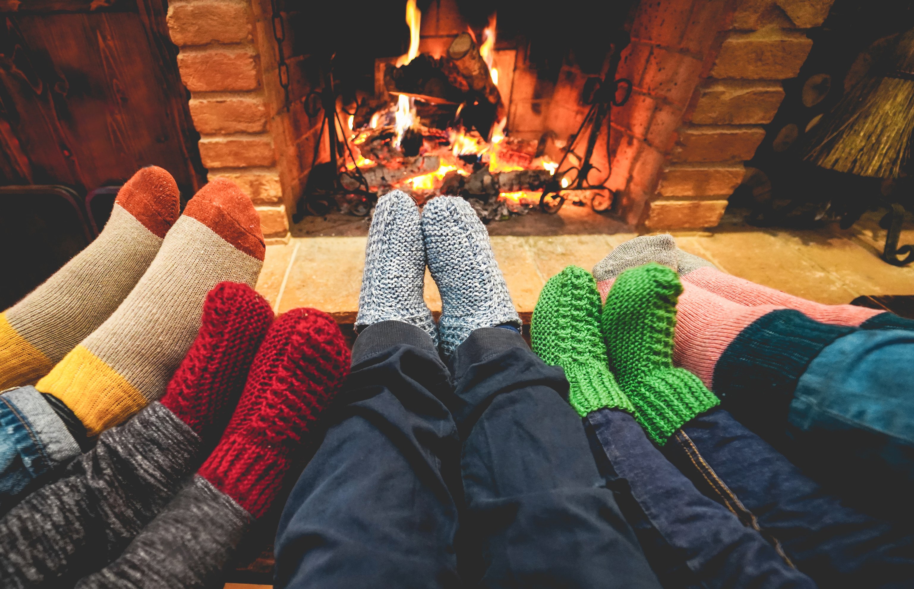 Happy family wearing warm socks in front of fireplace