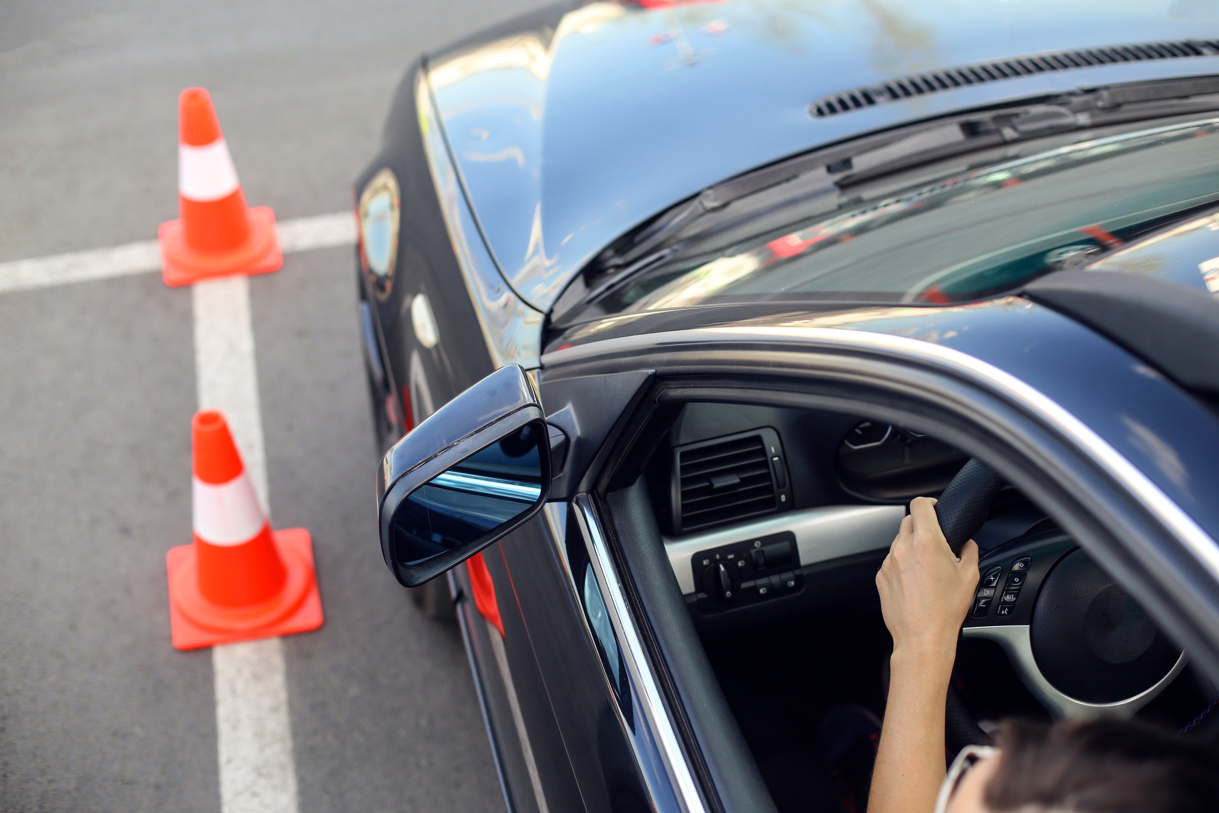  Young woman learning how to drive a car.