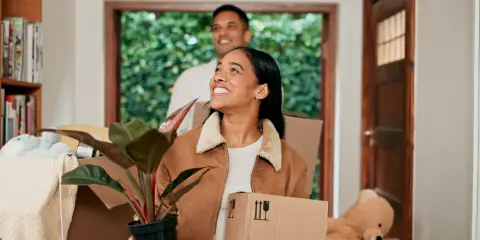 Happy couple moving into a new home with boxes