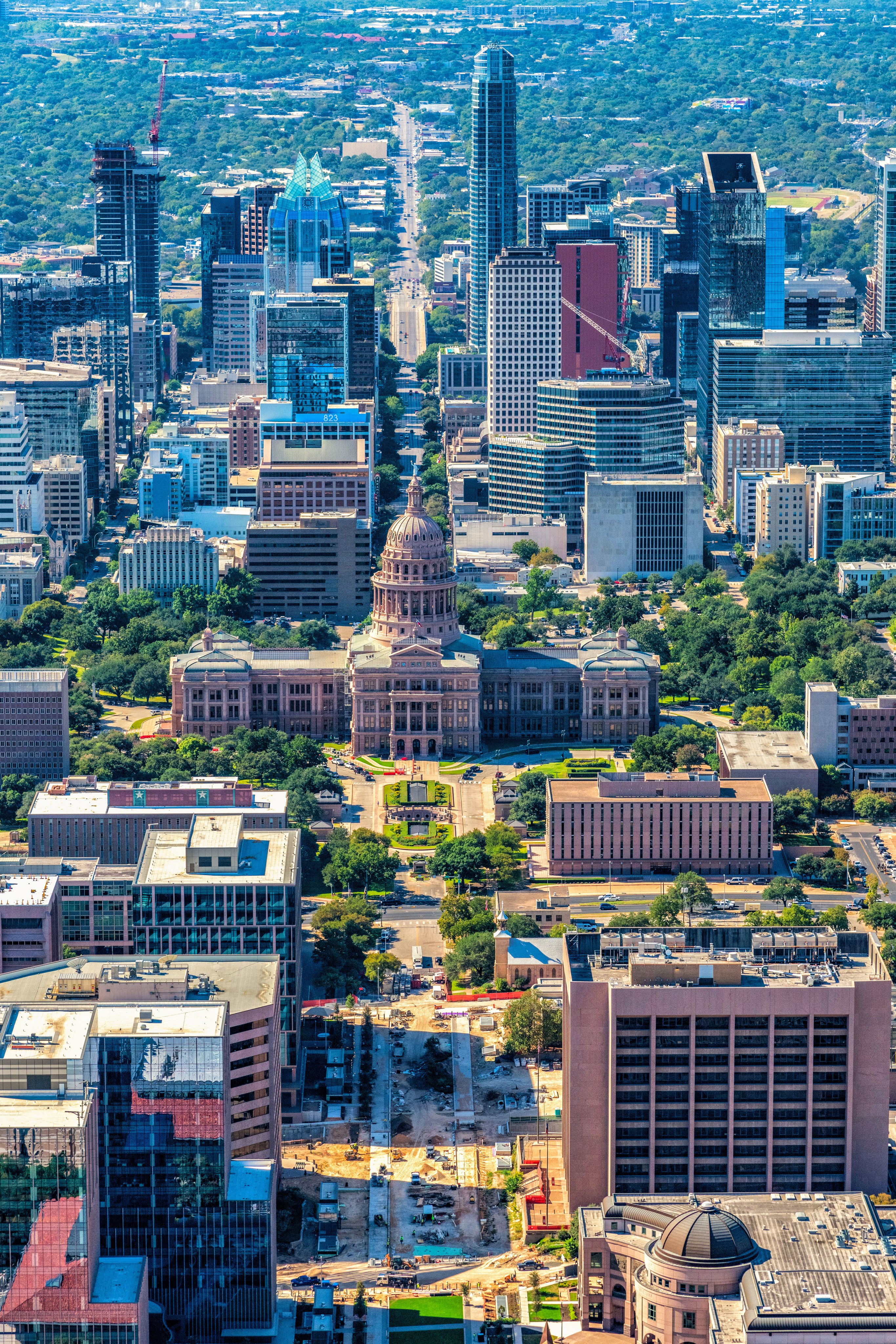 Aerial view of Texas State Capitol Building in the foreground with the skyline of Austin, Texas