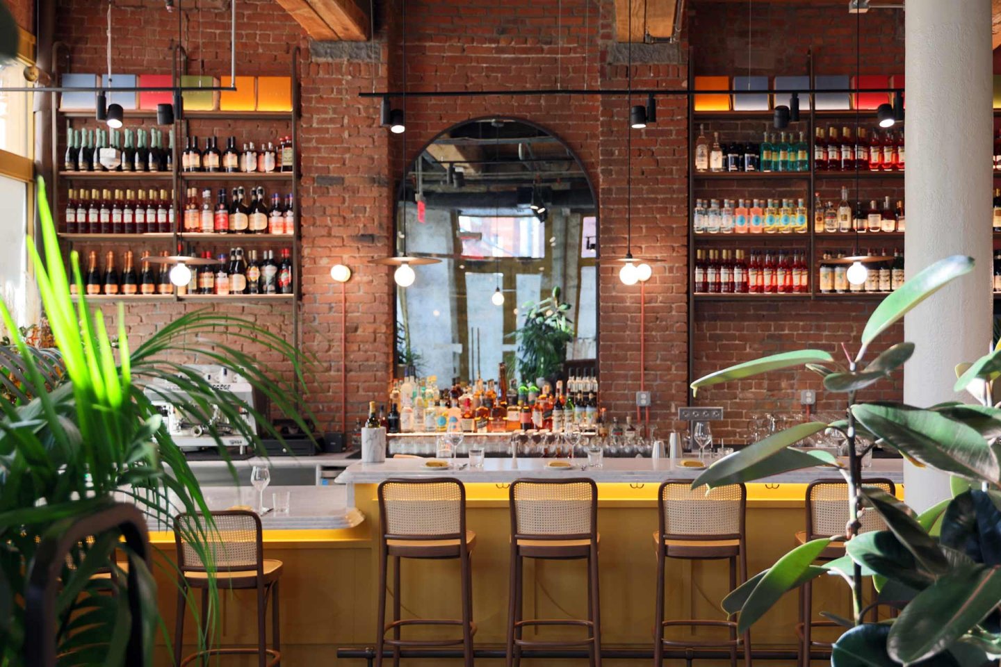 A bar with a bar and shelves of liquor.