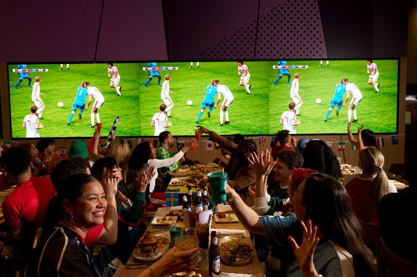 Group watching game with food and beverages at Dave & Buster's