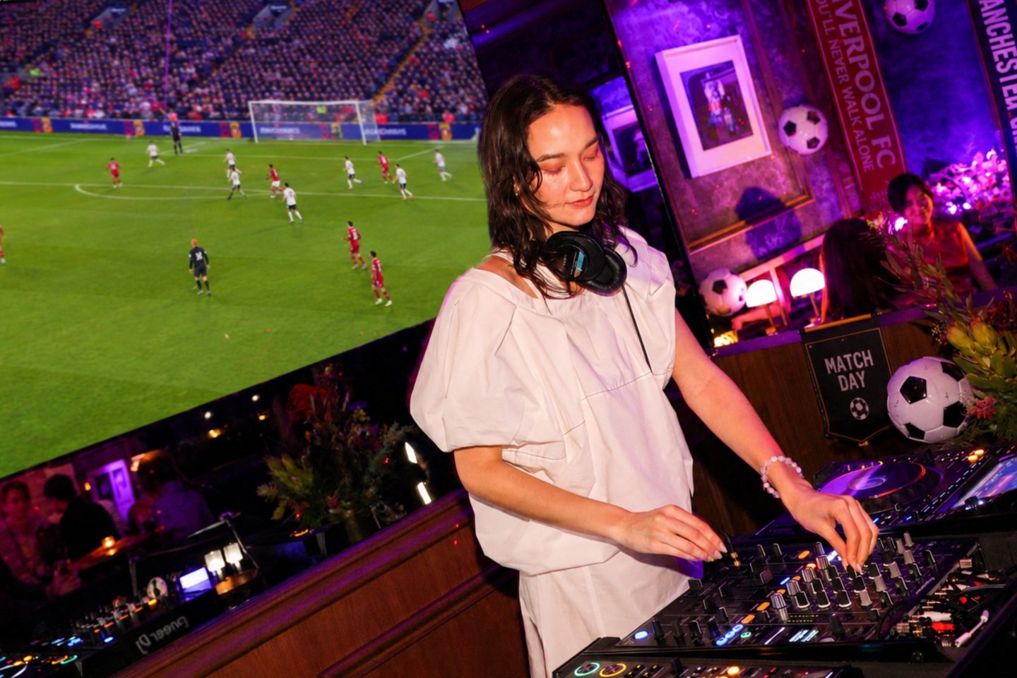 image of a DJ in the BA53MENT with soccer game playing