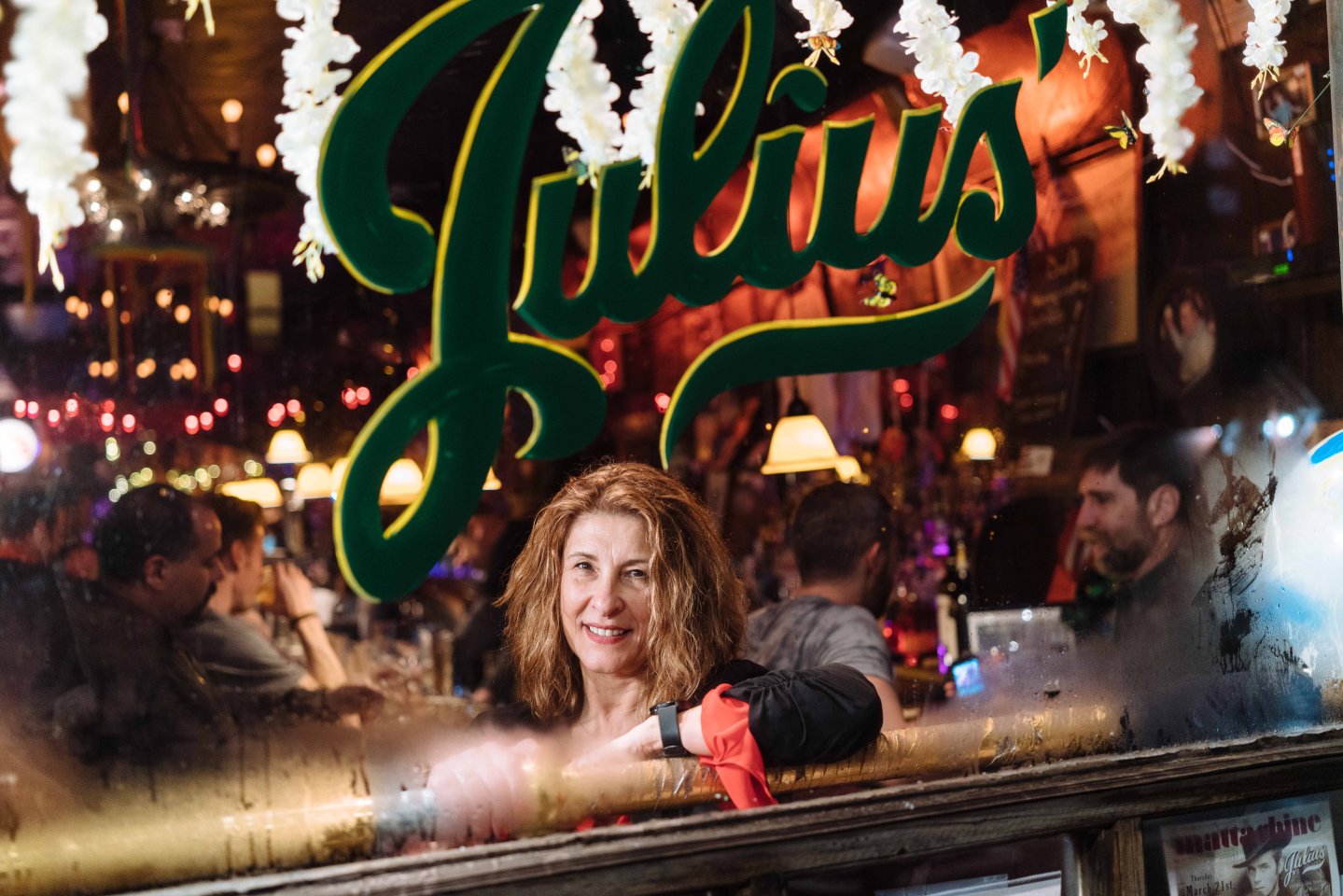 Person looking at the camera from inside of Julius, a bar in the West Village, Manhattan