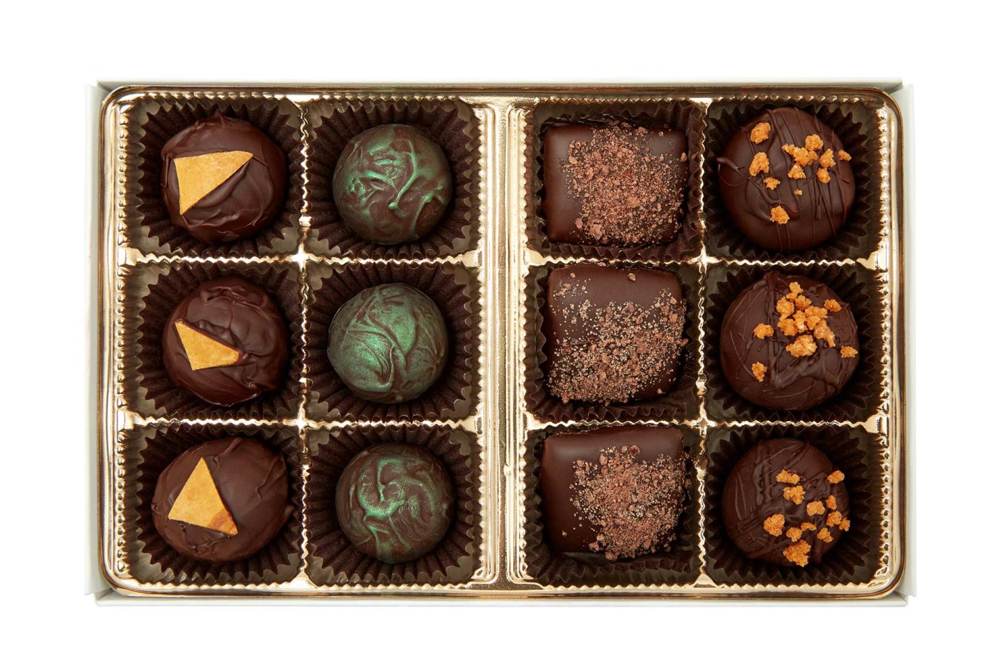 A box of twelve assorted gourmet chocolates, each in a brown paper cup, featuring various toppings and designs, including gold triangles, green swirls, cocoa dusting, and caramelized bits.