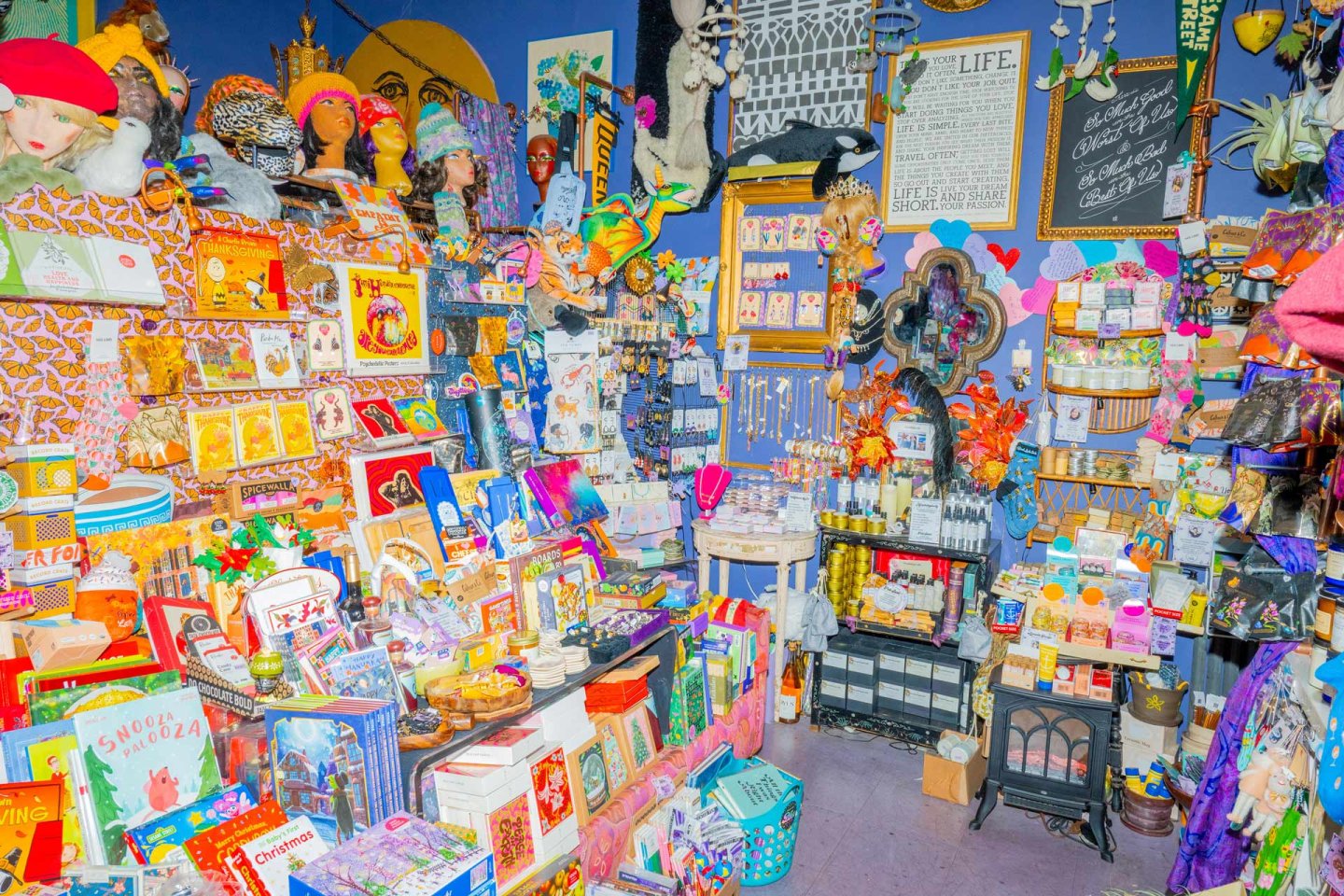 Bliss Vintage & Handmade, a colorful, crowded shop filled with assorted books, toys, hats, trinkets, decorations, and various gift items displayed on shelves.