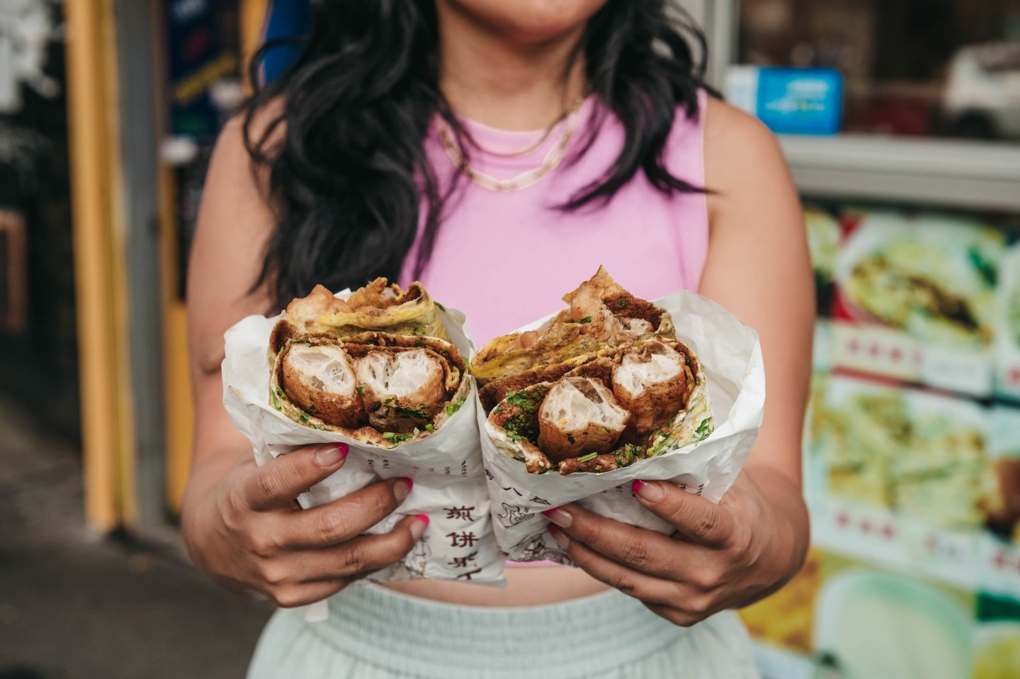 A person holds a crepe sandwich at Eight Jane