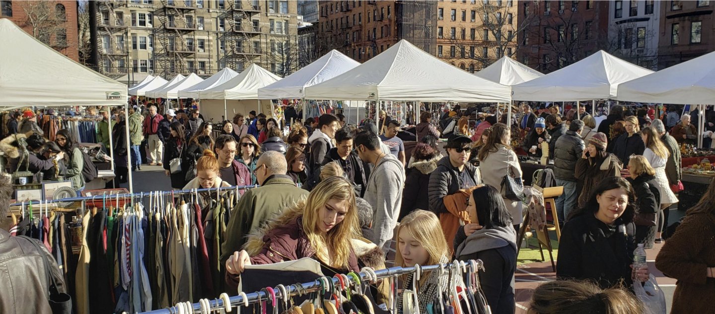 Crowds shopping among outdoor vendor tents at Grand Bazaar NYC on the Upper West Side in Manhattan.