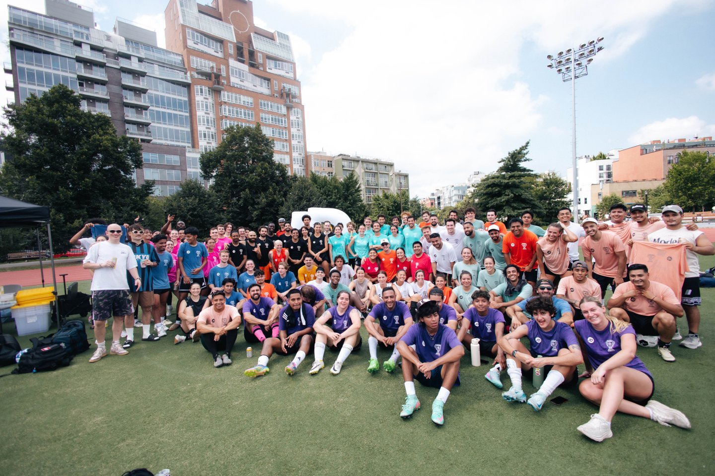 A large gathering of The Footy League's soccer players at last years Chopped Cheese Classic, posing together for a group photo at McCarren Park in Brooklyn.
