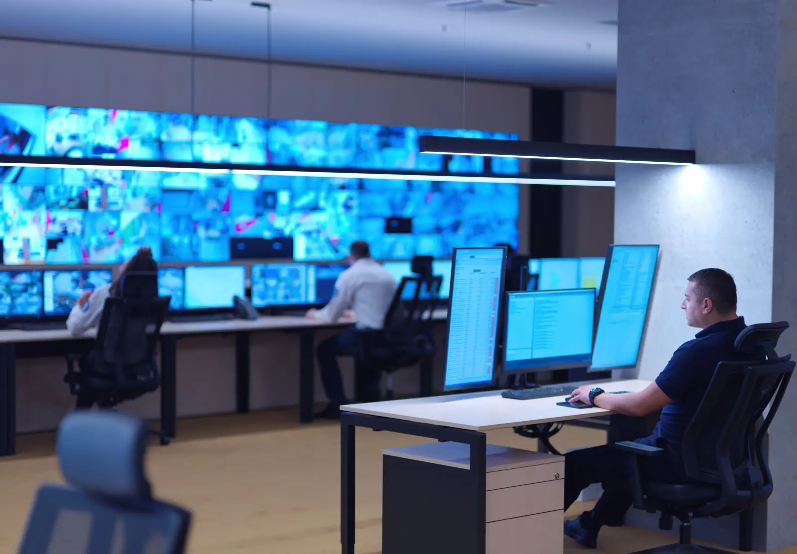 Male security operator working in a data system control room offices Technical Operator Working at  workstation with multiple displays, security guard working on multiple monitors  Male computer operator monitoring from a security center