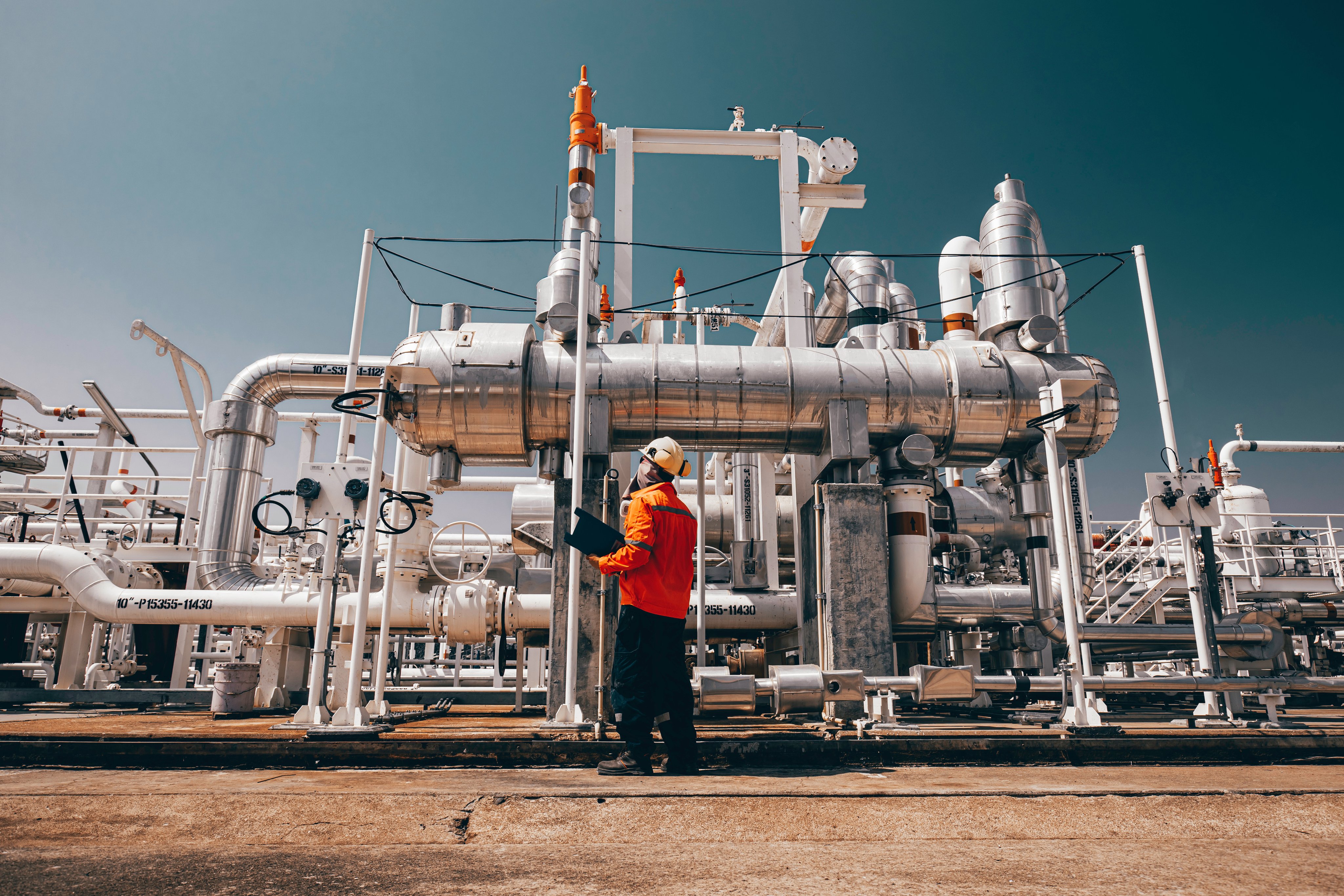 Male worker inspection exchanger afternoon of tank oil refinery pipeline plant steam vessel and column tank oil of Petrochemistry industry.