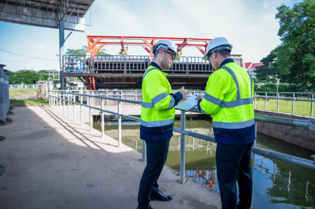 A specialist engineer and an inspector are working together to plan the expansion of the wastewater treatment plant structure.