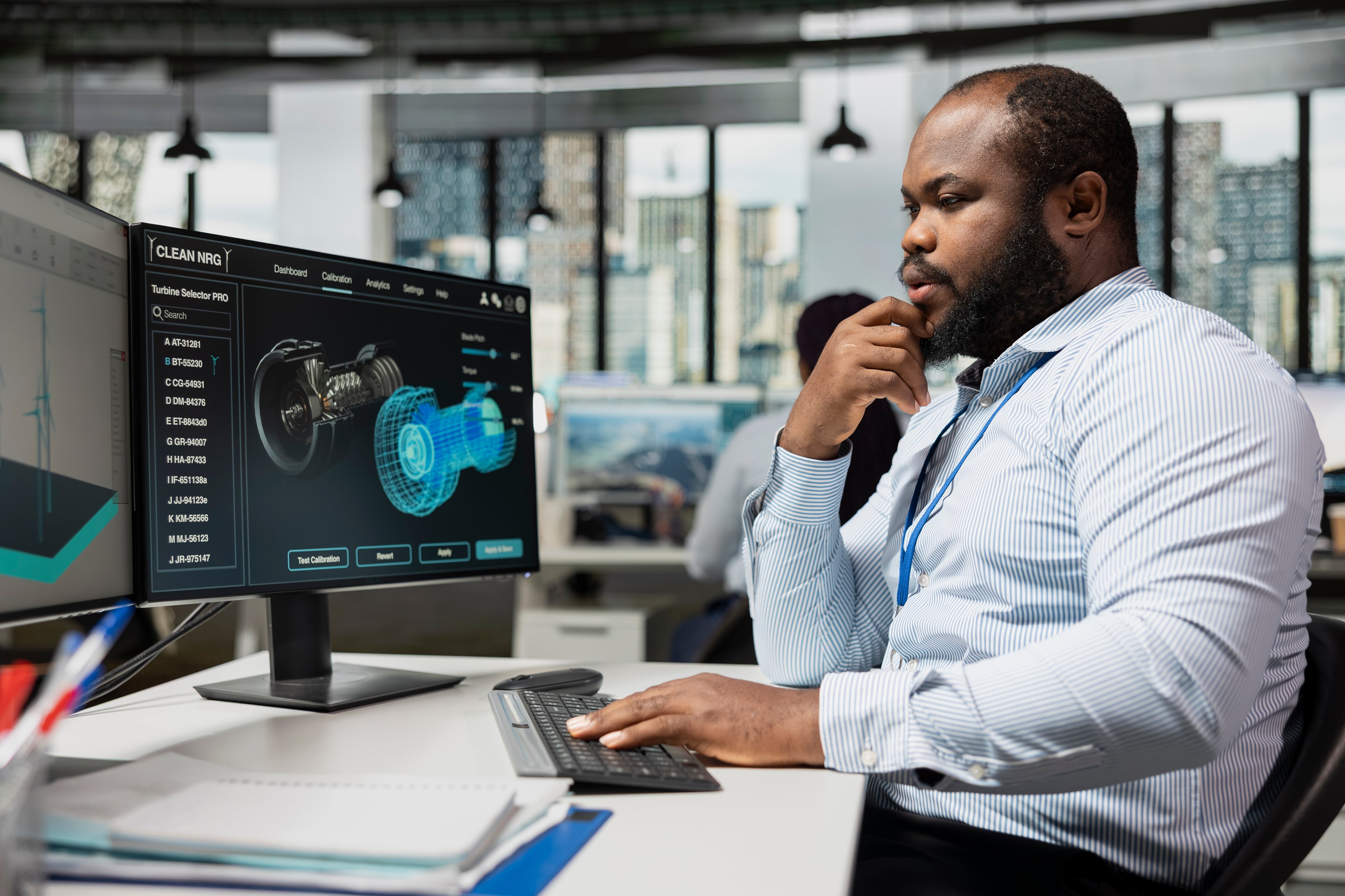 Employee uses CAD software to upgrade turbine, boosting power output and increasing sustainability. Research and development office worker reviews turbine data to optimize efficiency