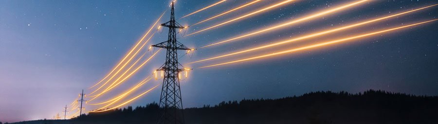 Electricity transmission towers with orange glowing wires the starry night sky. Energy infrastructure concept.